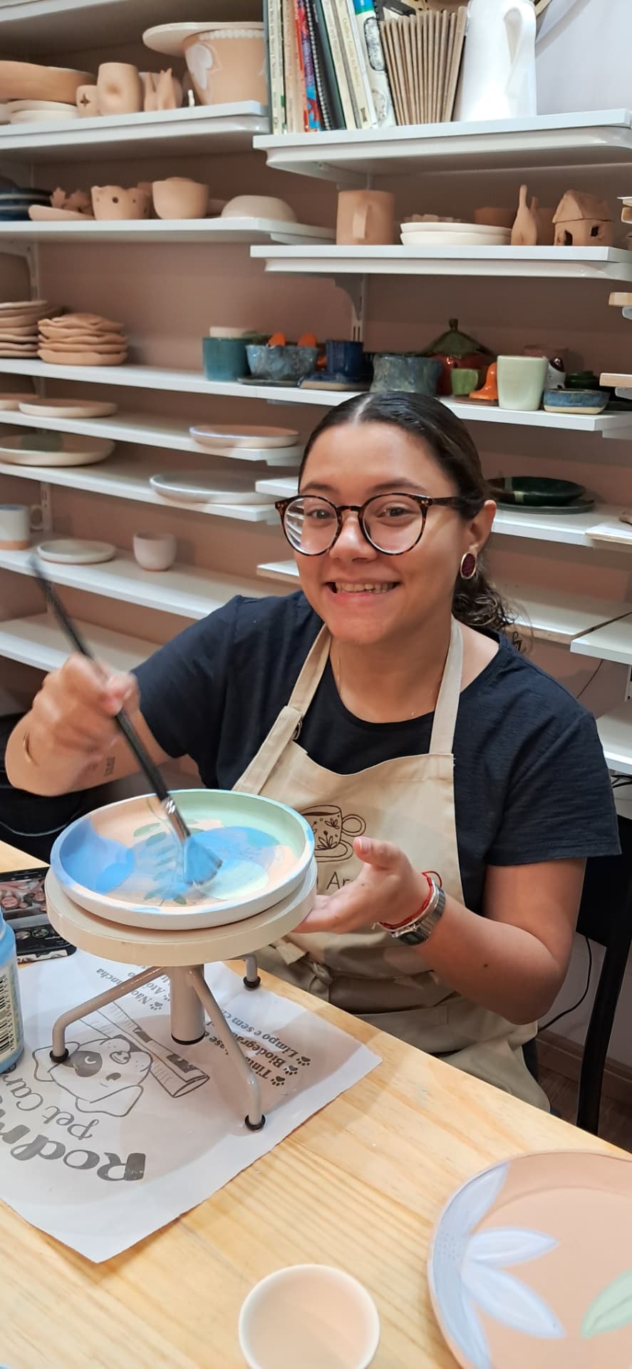 Aluna pintando um prato com esmalte azul